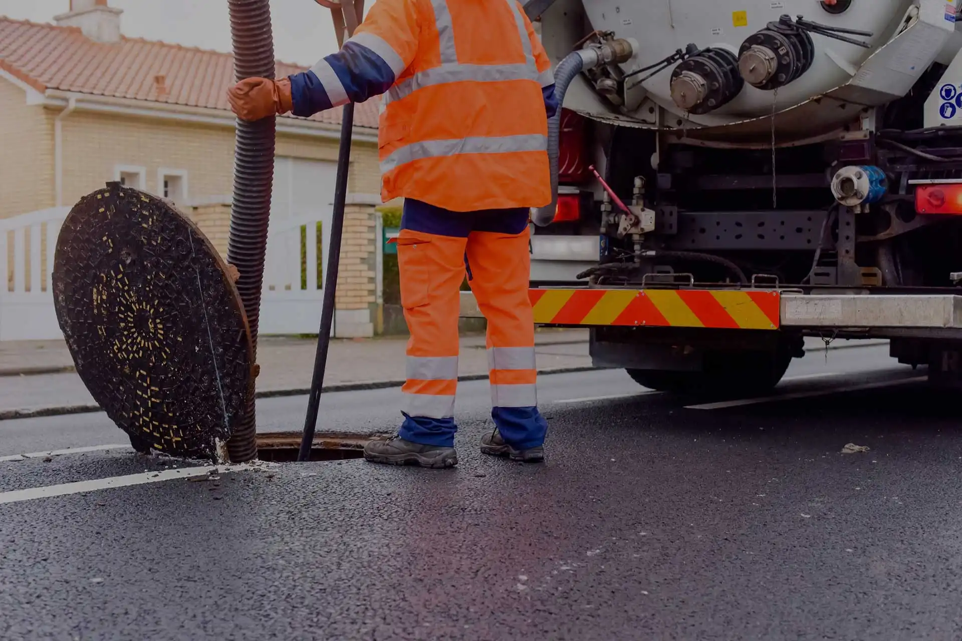 Expert de Klondike environnemental en action à effectuer un pompage d'eau usé sur la route avec camion et équipements